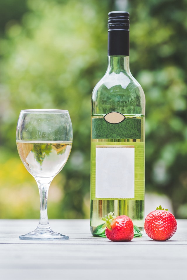white wine in glass and bottle with strawberries