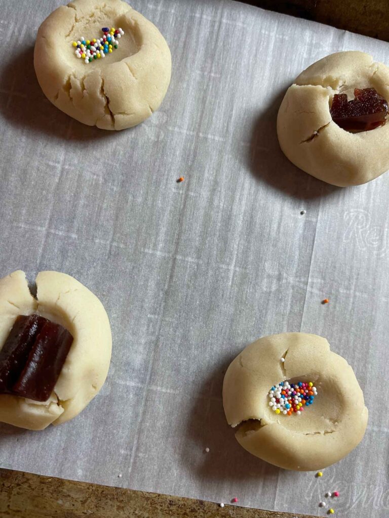 cookies with guava paste and sprinkles in an indent made by a thumb