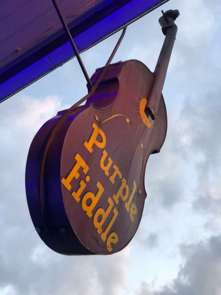 Purple Fiddle sign outside of their place in Thomas WV looks like a purple fiddle