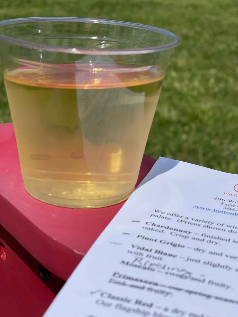 glass of white wine on a red chair with a list of wines to try