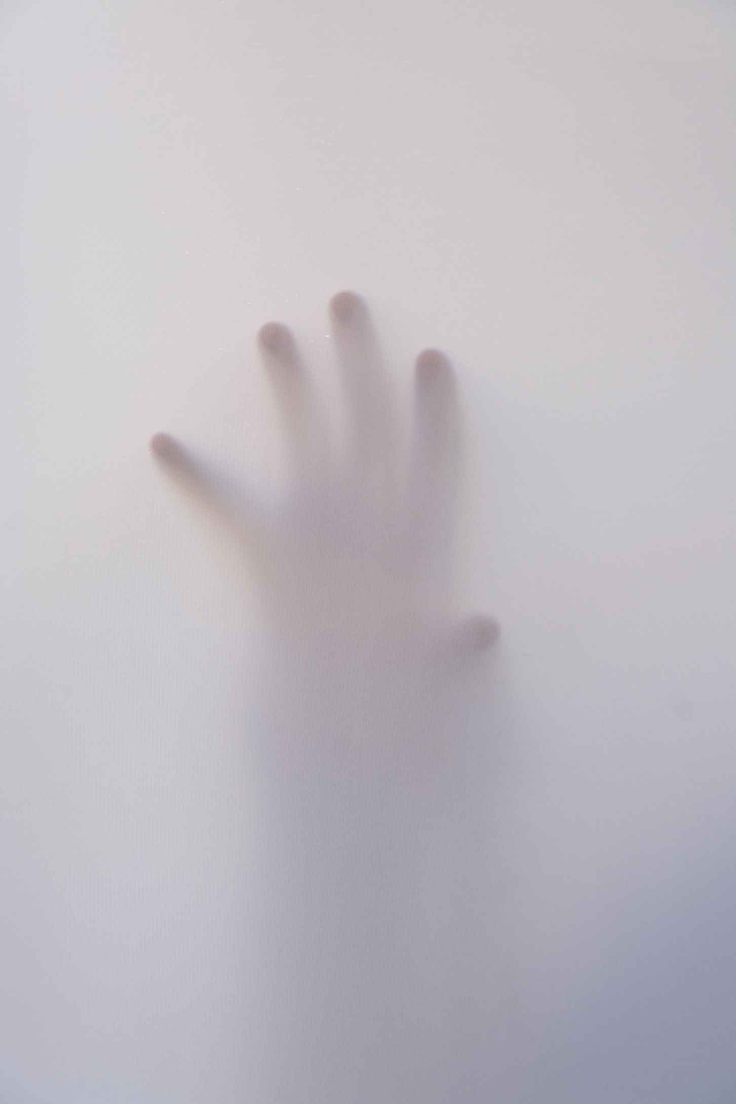 hand against a window and covered in mist