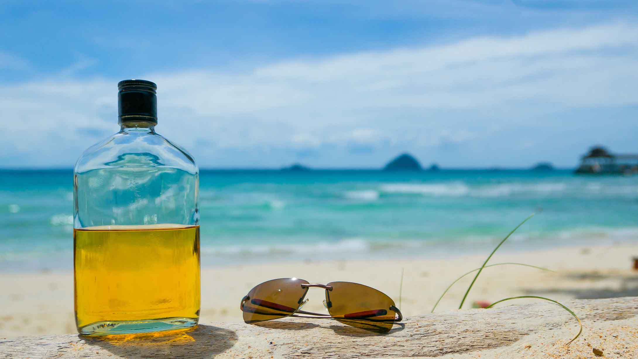list of spiced rum brands a rum bottle on the beach with sunglasses