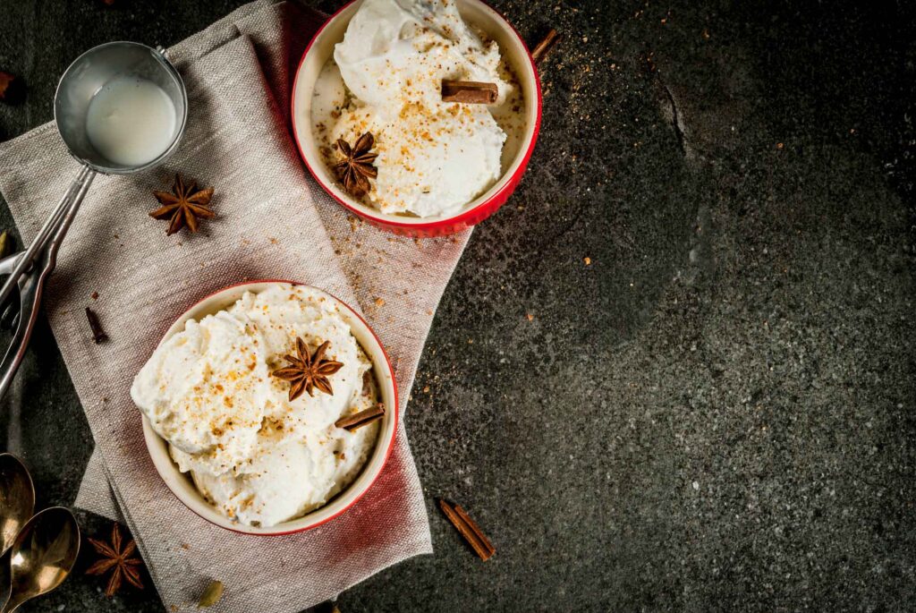 bowls of eggnog ice cream with an ice cream scoop