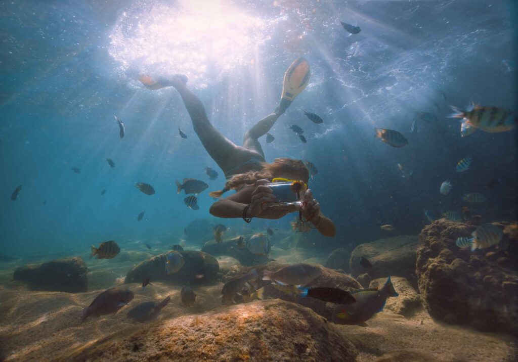 a person snorkeling and taking an underwater picture