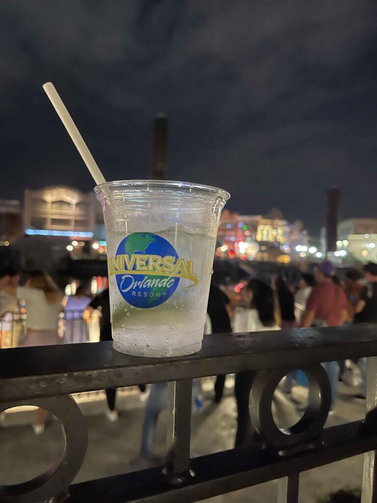 drink at Universal Orlando with park lights in the background
