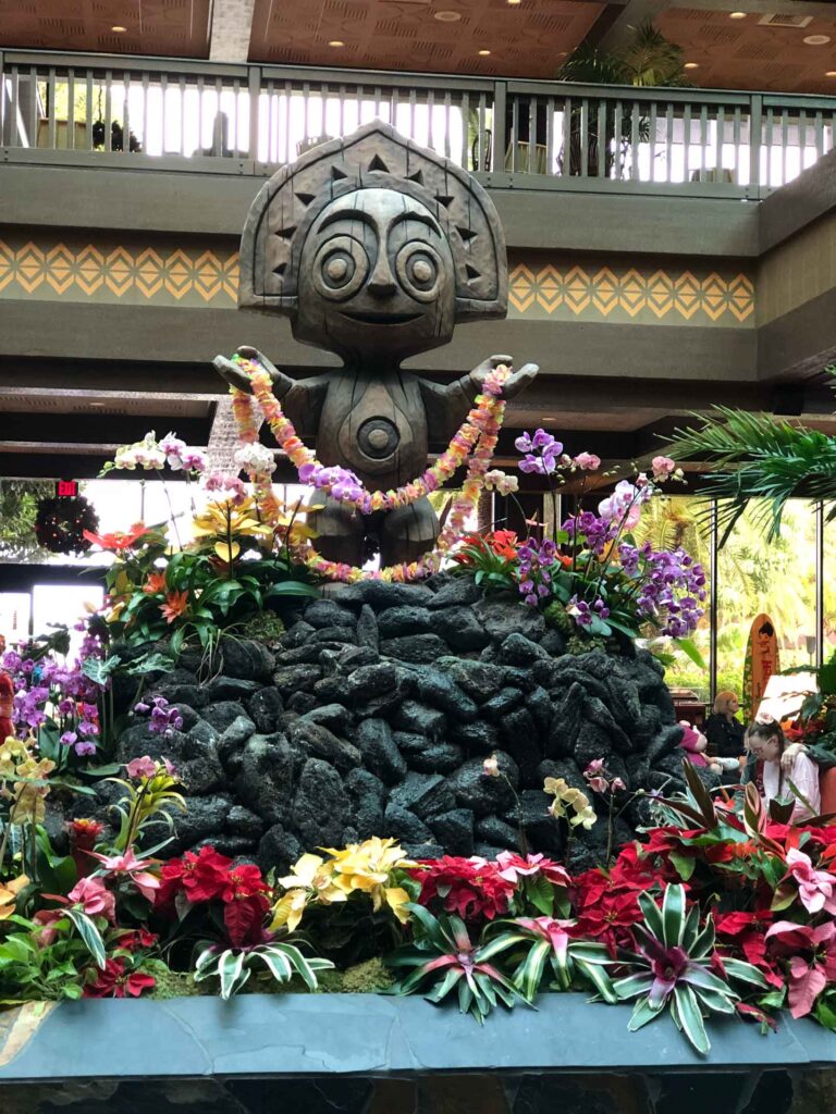 Lobby of the Polynesian Resort in Disney World.  the statue is covered is tropical flowers