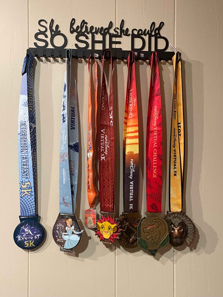 My  virtual 5k disney medals on the wall with a sign 